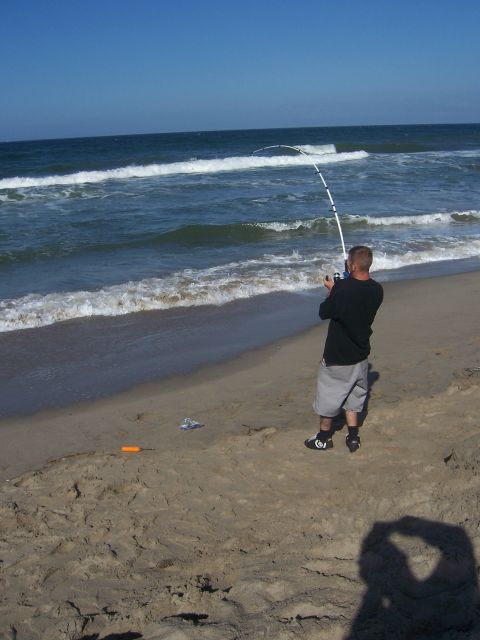 1991 Ford Bronco - A person enjoys a day of fishing by the ocean, casting a line into the surf.