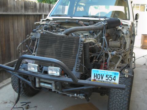 1990 Ford Bronco - Front view of a 1990 Ford Bronco undergoing modifications, showing the engine bay and custom bumper.
