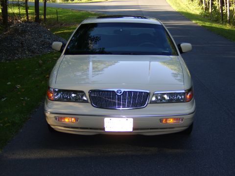 1996 Mercury Grand Marquis - Front view of a cream/tan Mercury Grand Marquis sedan parked on a paved driveway, showing its chrome waterfall grille, dual headlights, amb…