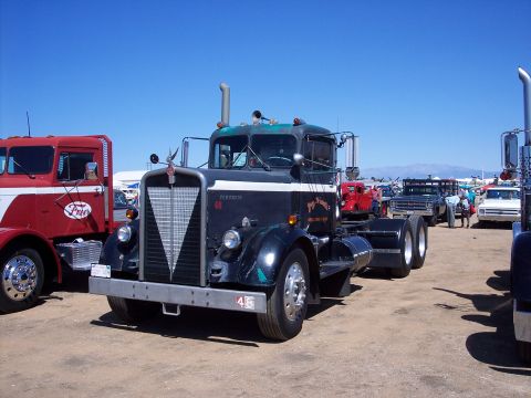 1981 Kenworth W900A - A classic 1981 Kenworth W900A semi-truck is displayed at an outdoor event alongside other trucks.