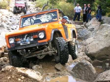 1995 Ford Bronco - First-gen Ford Bronco tackling a difficult rocky trail with another vehicle behind it.