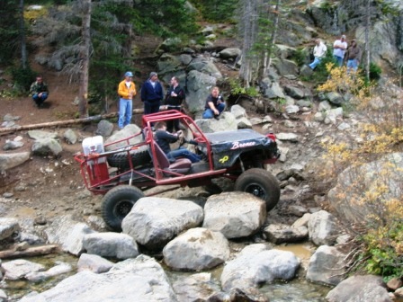 1995 Ford Bronco - This custom buggy navigates a challenging rocky terrain with spectators observing the off-road action.