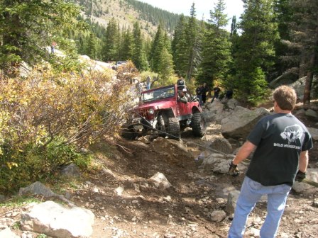 1995 Ford Bronco - Off-road vehicle navigates challenging rocky terrain with assistance.