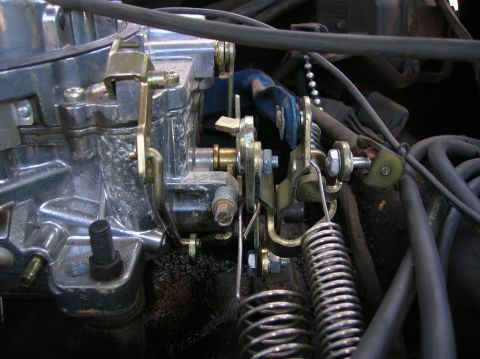 1978 Ford F-250 - Detail of the throttle linkage and return springs on a vehicle's carburetor.