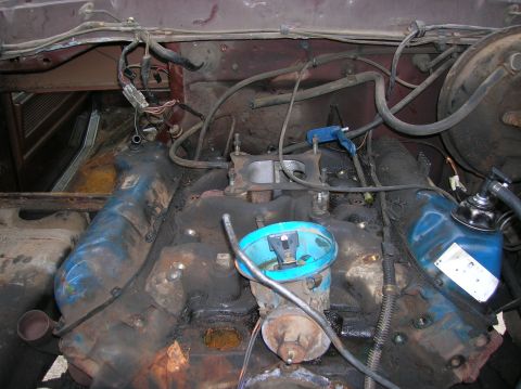 1978 Ford F-250 - Engine bay of a 1978 Ford F-250, showing the carburetor and distributor during a teardown.