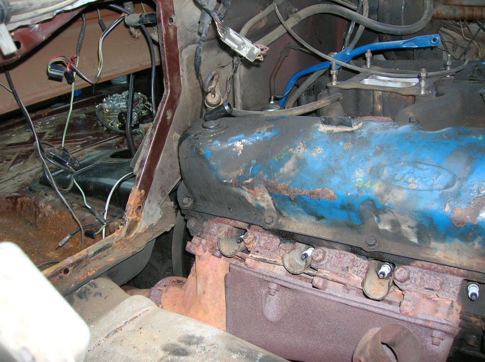 1978 Ford F-250 engine bay, blue valve covers, rusty exhaust manifold, visible spark plugs