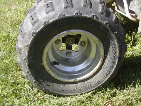 1991 Ford Bronco - ATV wheel and tire detail shot on a grassy surface.