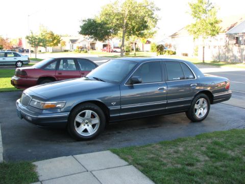1985 Mercury Grand Marquis - A dark blue Mercury Grand Marquis is parked on a driveway with another car behind it.