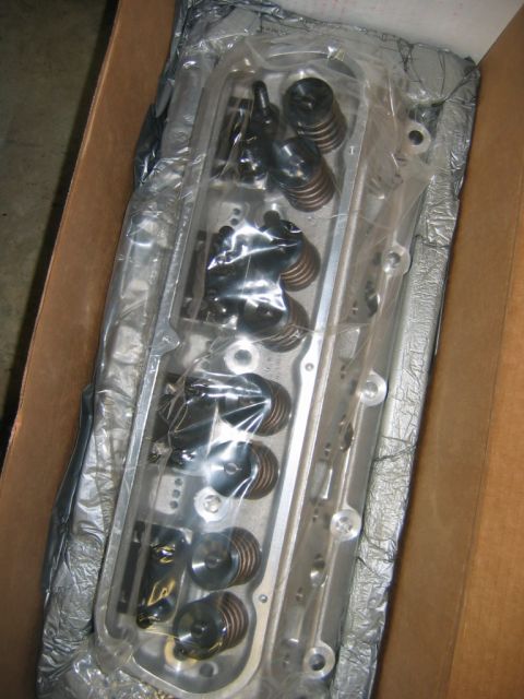 1992 Ford Mustang - A new engine cylinder head, still in its protective packaging, sits inside a cardboard box.