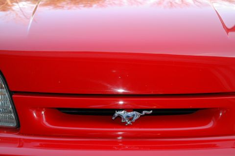 1993 Ford Mustang - Front view of a red 1993 Ford Mustang Cobra, showing the grille and iconic running horse emblem.