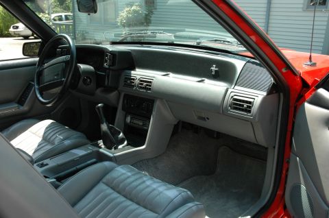 1993 Ford Mustang - The interior of a 1993 Ford Mustang shows gray leather seats and a dashboard with a manual shifter.