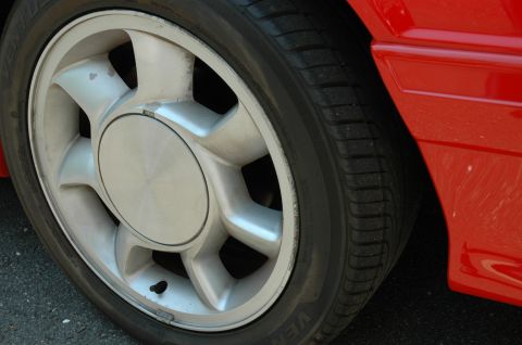 1993 Ford Mustang - Detail shot of a red car's wheel and fender section.