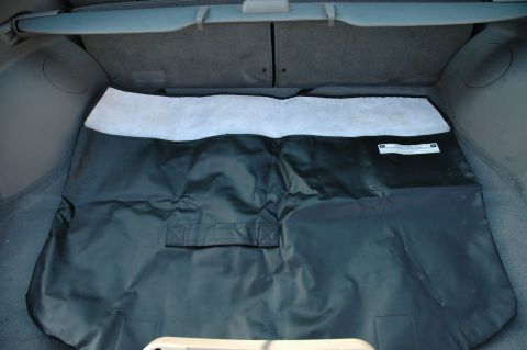 1993 Ford Mustang - Interior view of a car's trunk showing a folded black liner with white trim and a label.