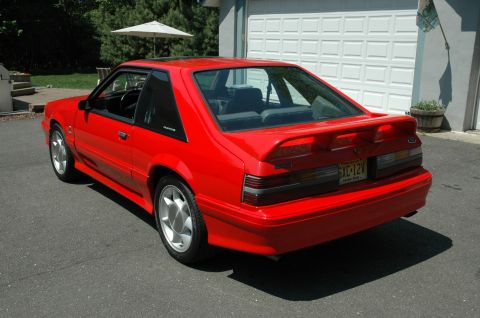 1993 Ford Mustang - Rear view of a red 1993 Ford Mustang with a spoiler and a New Jersey license plate.