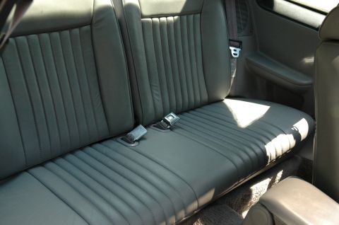 1993 Ford Mustang - Interior view of a car's rear seat with gray upholstery and seat belts.