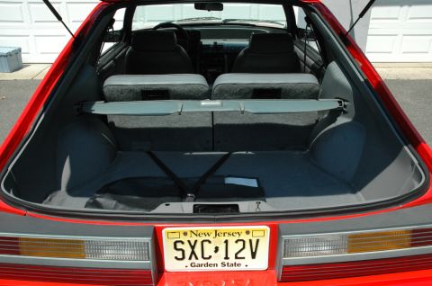 1993 Ford Mustang - The interior and trunk of a red 1993 Ford Mustang are visible, the New Jersey license plate SXC 12V.