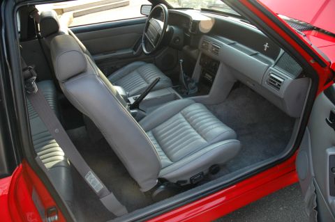 1993 Ford Mustang - The interior of a 1993 Ford Mustang features grey leather seats and a red exterior.