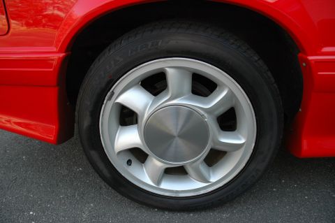 1993 Ford Mustang - A close-up view of a red car's wheel and part of the fender.