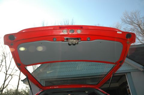 1993 Ford Mustang - The interior of a car's open trunk reveals the latch mechanism and the underside of the lid.
