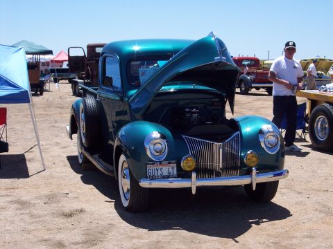 1981 Kenworth W900A - A classic teal pickup truck from the 1940s is displayed with its hood open at an outdoor event.