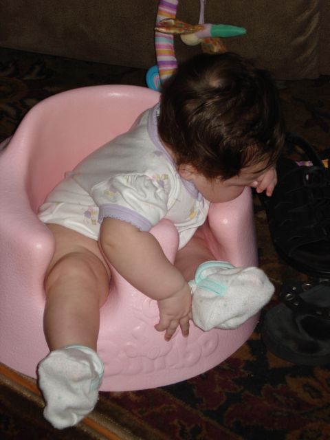 2000 Ford Crown Victoria - A baby sits in a pink infant seat, looking down at their feet.