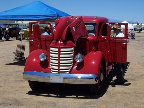 1981 Kenworth W900A - A classic red truck is displayed outdoors with its hood and doors open, revealing its engine and interior.
