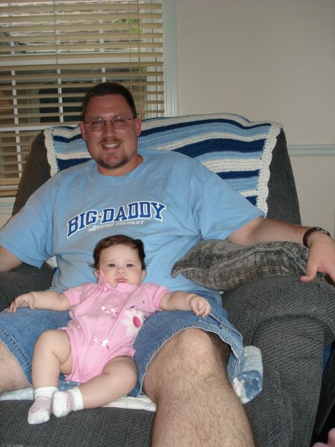 2000 Ford Crown Victoria - A man and a baby are sitting in a chair, with a blanket draped over the back of the chair.