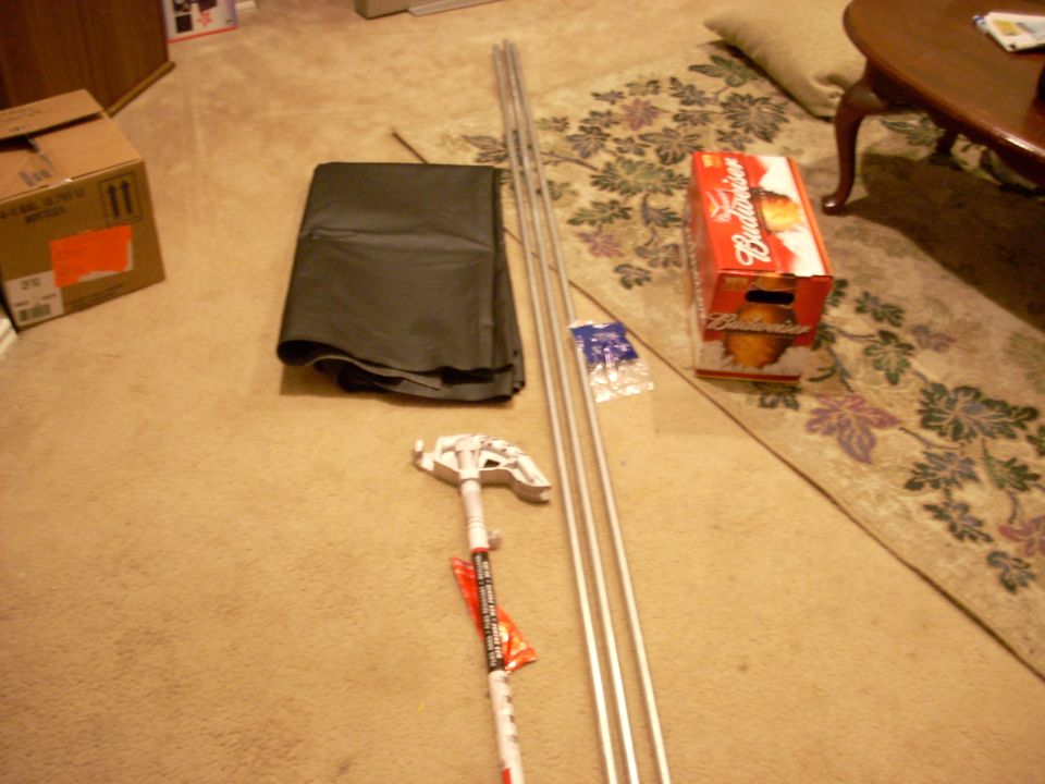 Black vinyl top folded on carpet with aluminum bows, hardware bag and mounting bracket