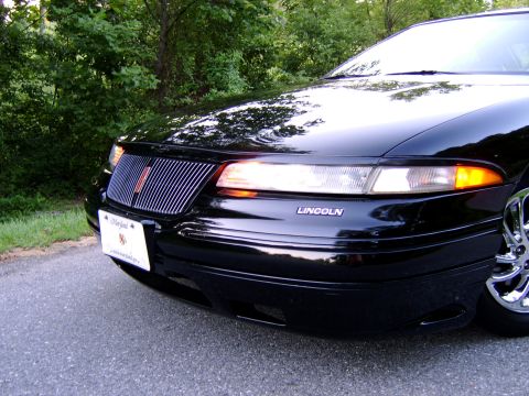 1996 Mercury Grand Marquis - A black Lincoln sedan is shown from the front, with a Maryland license plate.