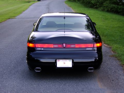 1996 Mercury Grand Marquis - Rear view of a black Lincoln Mark VIII sedan parked on a paved driveway.