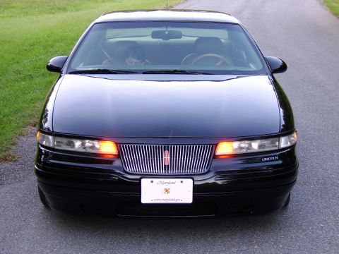 1996 Mercury Grand Marquis - Front view of a black Lincoln sedan with its hazard lights on.