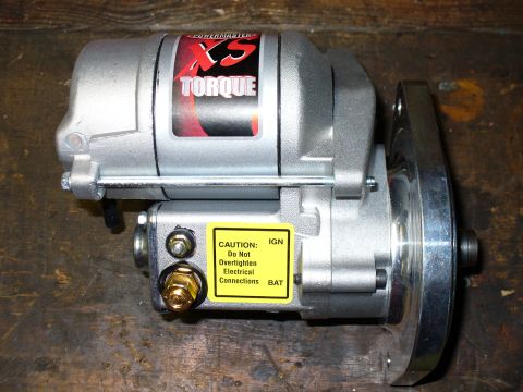 1978 Ford Bronco - A new Powermaster XS Torque mini gear-reduction starter sits on a wooden workbench, side view showing the silver housing with red XS Torque…