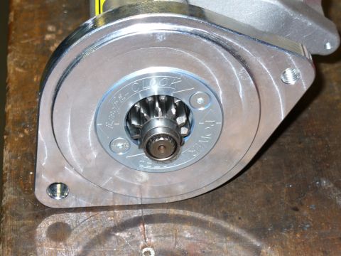 1978 Ford Bronco - Close-up of a new aluminum-cased gear-reduction starter motor lying on a wood bench, showing the triangular mounting flange and the splined…