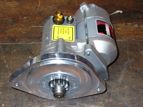 1978 Ford Bronco - Automotive starter motor shown on a wooden surface. Label warns about electrical connections.