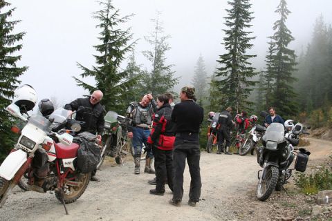 1979 Ford Bronco - A group of motorcyclists gathered on a dirt road surrounded by trees on a foggy day.