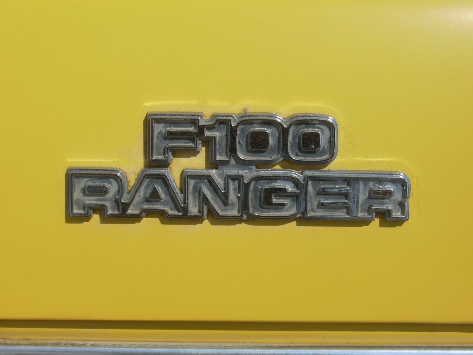 Chrome F100 RANGER emblem on a yellow body panel