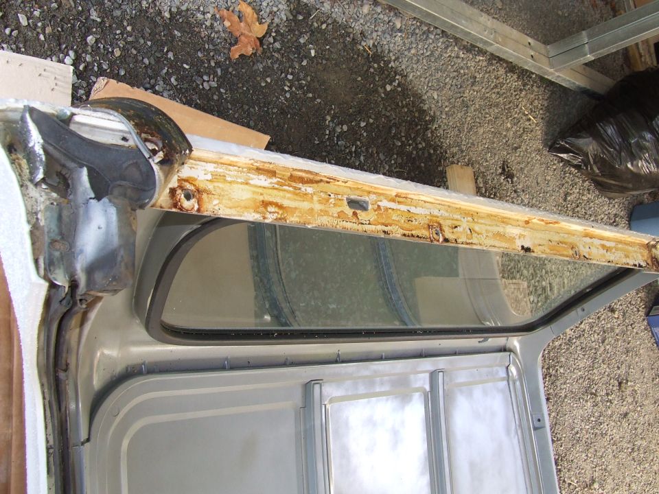rusted door frame with window opening, showing metal and wood structure