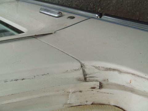 1979 Ford Bronco - Close-up of a white vehicle's body panel showing wear and tear.