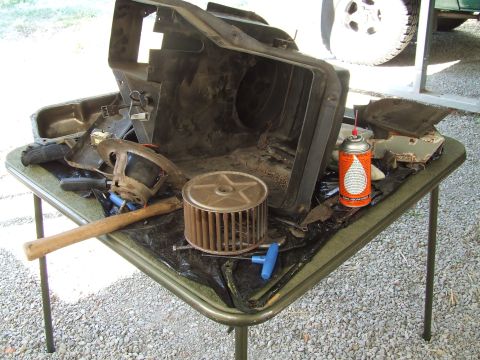 1979 Ford Bronco - Various disassembled vehicle parts are laid out on a folding table for repair.