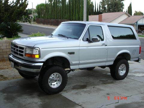 1996 Ford Bronco - This silver 1996 Ford Bronco is shown from a 3/4 front angle, highlighting its lifted suspension and overall body style.
