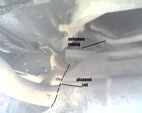 1990 Ford Bronco - The underside of a vehicle shows exhaust components and tubing, with annotations indicating a planned cut.