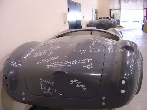 1996 Ford Bronco - Car body covered in signatures, possibly a replica or kit car, with another car in the background.