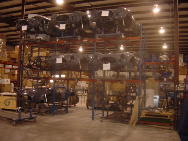 Car bodies stored on industrial racks inside a warehouse