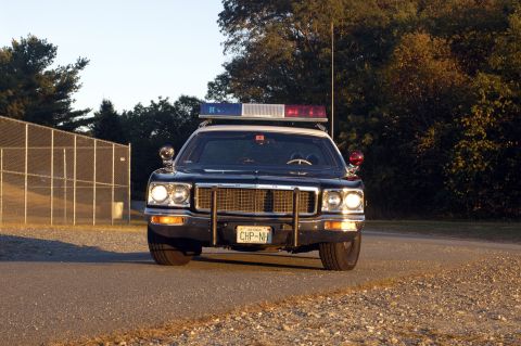 1973 Dodge 1500 - Front view of a 1973 Dodge 1500 police car parked on a road.