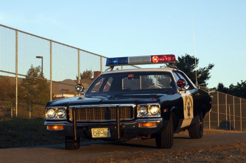 1973 Dodge 1500 - Front view of a 1973 Dodge 1500 police car, equipped with a light bar and push bumper.