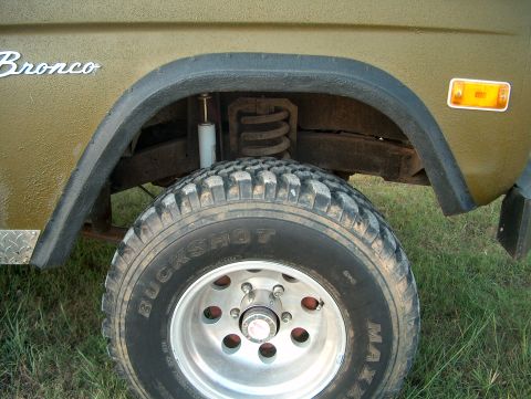 1979 Ford Bronco - Close-up of a 1979 Ford Bronco's front wheel and fender assembly.