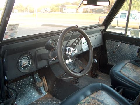 1979 Ford Bronco - The interior of a 1979 Ford Bronco features diamond plate flooring and door panels, along with camouflage seat inserts.