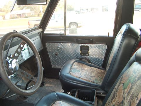 1979 Ford Bronco - Interior view of a 1979 Ford Bronco with custom diamond plate door panels and camouflage seat covers.