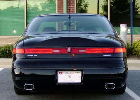 1996 Mercury Grand Marquis - Rear view of a black Lincoln Mark VIII, its distinctive horizontal taillights and dual exhaust pipes.