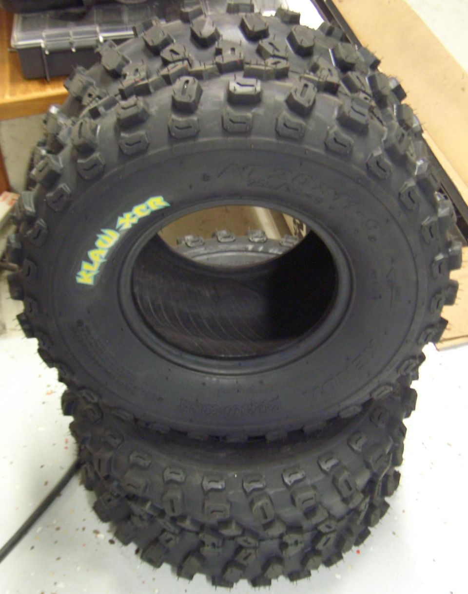 Pair of stacked knobby Klaw XCR ATV tires on a shop floor
